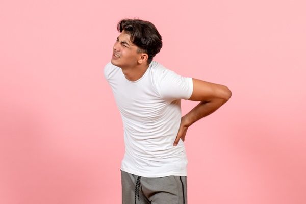 Dolor de espalda - Hombre con gestos de dolor lumbar debido a una contractura muscular