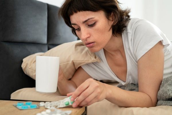 Enfermedades - Mujer tomando medicamentos para tratar una infección por virus que han aparecido en la última década