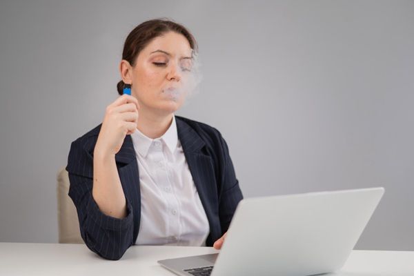 Enfermedades - Mujer usando un cigarrillo electrónico que puede causar alguna enfermedad autoinmune de lesión pulmonar relacionada con el vapeo