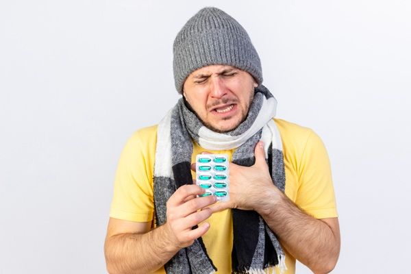 Rinitis alérgica - Hombre sosteniendo pastillas para alergia que ayudan a controlar la rinitis alérgica o fiebre del heno