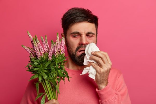 Rinitis alérgica - Hombre con congestión nasal debido a la alergia que causa el polen de las flores