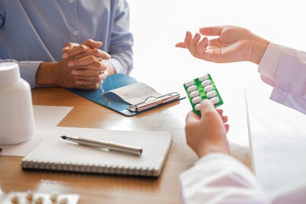 Automedicación - Médico recentando medicamentos a un paciente para aliviar los síntomas de manera segura sin automedicarse