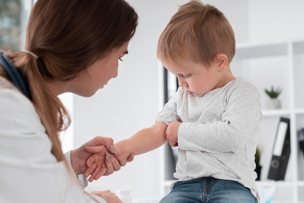 Enfermedad de Kawasaki - Pediatra evaluando a un niño con síntomas de hinchazón y enrojecimiento en la piel para diagnosticar la enfermedad de Kawasaki