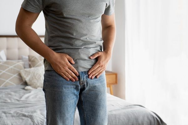 Próstata inflamada - Hombre poniendo sus manos en la pelvis debido a dolores causados por la hiperplasia