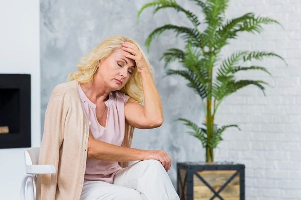 Síntomas de la menopausia - Mujer sintiendo sofocos debido a los síntomas de la premenopausia