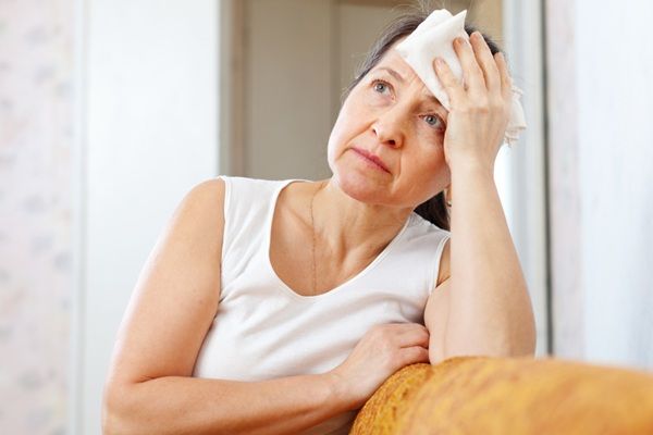 Síntomas de la menopausia - Mujer con calores y sofocos debido a los cambios hormonales generados por la menopausia
