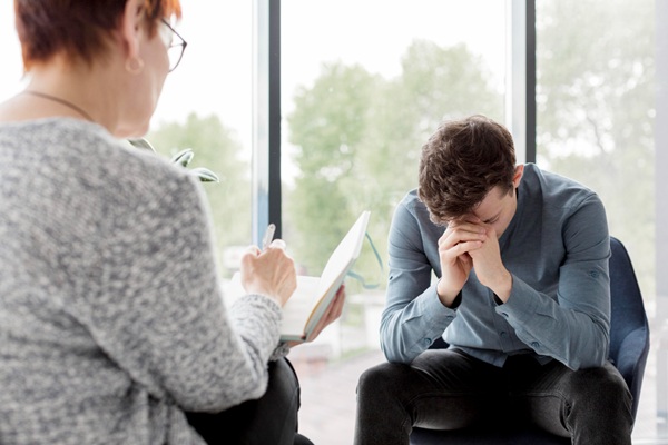 Trauma psicológico - Psicólogo evaluando a un hombre para determinar los tipos de trauma psicológico que afectan su vida