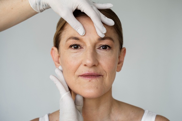 Rejuvenecimiento facial - Médico estético evaluando el rostro de una mujer para recomendar el mejor tratamiento para las arrugas