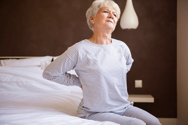 Achaques de la edad - Mujer madura con dolores de espalda debido a la rigidez que causa el achaque de la edad