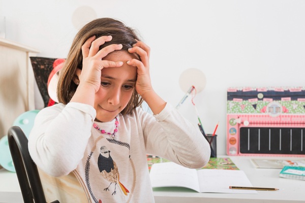 Niña frustrada debido a las dificultadas que presenta para concentrarse a causa de un trastorno genético