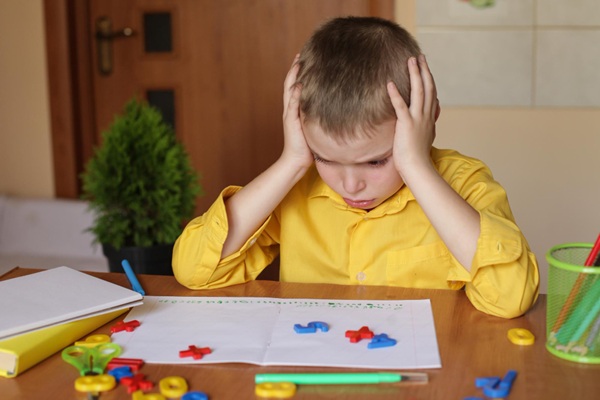 Niño con problemas para aprender letras y números debido a una alteración genética que provoca retraso en el desarrollo