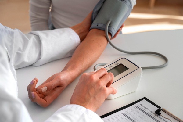 Enfermedades asintomáticas - Médico realizando un chequeo rutinario de la tensión a un paciente sin síntomas de hipertensión