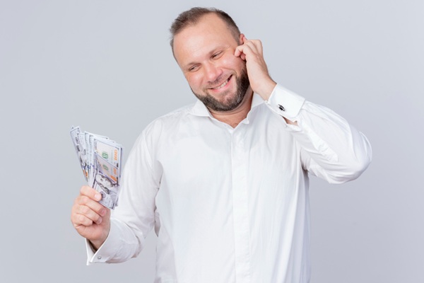 Implante capilar precio - Hombre sosteniendo billetes en su mano dudando sobre el precio del implante capilar Madrid