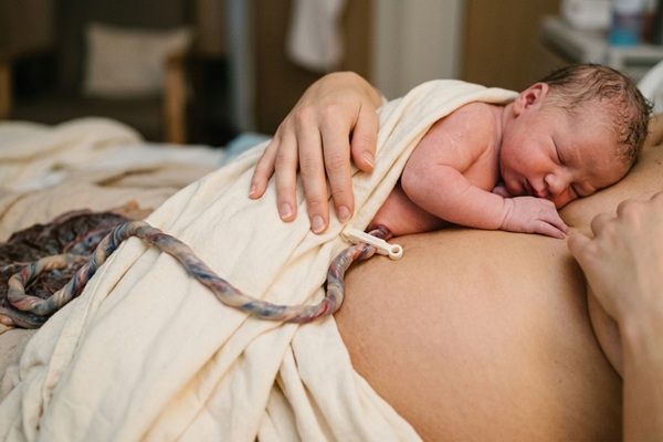 Cordón umbilical - Madre acostada con el bebé antes del procedimiento de guardar cordón umbilical